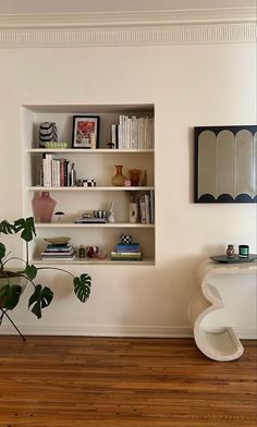 a living room filled with furniture and bookshelves next to a wall mounted mirror