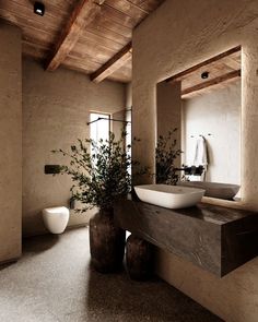 a bathroom with a bowl sink and two vases on the counter next to it