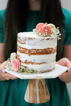 a woman holding a cake with fruit on it