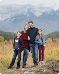 a family posing for a photo in front of mountains