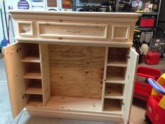 an unfinished wooden cabinet in a garage