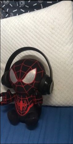 a spider - man headphone sitting on top of a bed next to a pillow