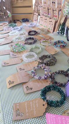 many bracelets are laid out on a table with tags and price tags attached to them