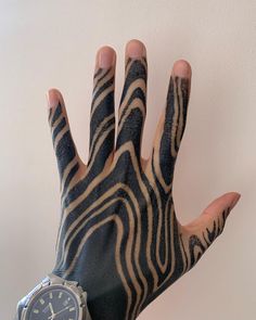 a person's hand with zebra print on it and a watch in the other hand