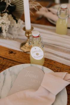 a table setting with flowers, candles and personalized items on the placemats