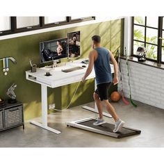 a man is walking on a treadmill with a monitor in the back ground and other objects around him