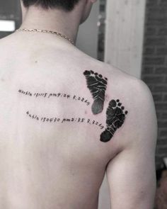 a man with a tattoo on his back that has footprints and words written in different languages