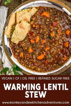 a bowl full of lentil stew with bread on the side