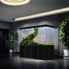 a large fish tank sitting on top of a hard wood floor next to a plant