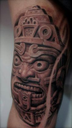 a man's leg with a tattoo on it that has an image of a tiki