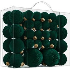 green ornaments are in a clear box with gold accents on the sides and bottom part