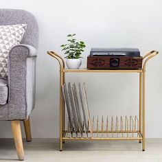 a couch and table with books on it next to a plant in a potted planter