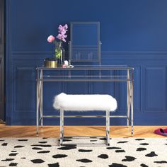 a white bench sitting in front of a mirror on top of a wooden floor next to a rug