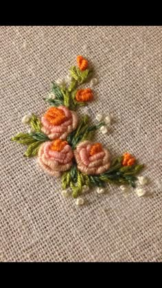 an embroidered piece of cloth with flowers on it