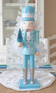 a nutcracker figurine is standing in front of a white christmas tree