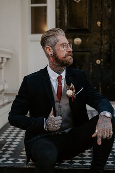 Tattooed Groom in Smart Suit and Glasses Men’s Alternative Wedding Suit, Menswear Wedding Casual, Stylish Groom Attire, October Wedding Suits Men, Groom Suit Vest, Men Black Wedding Suit, Stylish Groom Suit, Tattooed Man In Suit, Alternative Groom Outfit