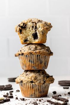 three muffins stacked on top of each other with chocolate chips scattered around them