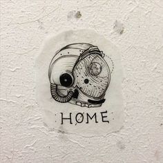 a drawing of a helmet with the words home written below it on a white wall