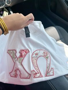 a person holding up a t - shirt with the letters xo and y on it