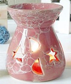 a pink vase sitting on top of a counter next to a candle holder with red and white stars