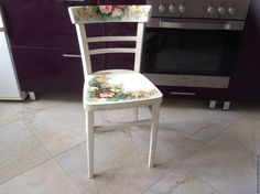 a white chair with flowers painted on it in front of an oven and stove top