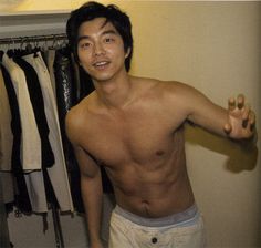 a shirtless man is standing in front of some clothes