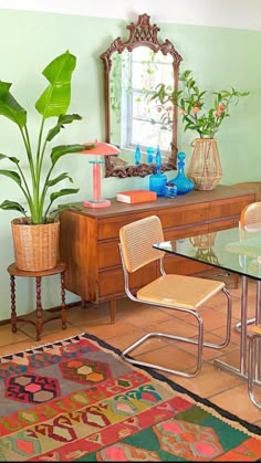 a dining room table with chairs and a rug on the floor next to a dresser