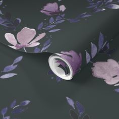 a wallpaper with purple flowers and leaves on black background, it looks like the wrapping paper has been rolled up