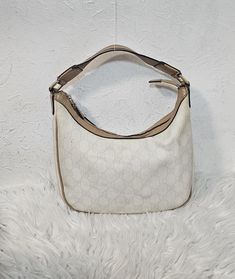 Gucci GG mini hobo bag in which canvas and fabric lined exterior. Cute and compact, it features a top handle, top zip closure, and slip pocket.  Interior is visibly discoloured and stained.  Exterior is good, has some mild markings and discoloured. Rubbing/scuffs on on bottom edges and top corners. Abrasions and creasing around strap. Note the flaw on the leather hold. No damage, no rips to this piece. No dust bag and no added accessories. Measurement: H - 16cm W - 25cm D - 5cm I offer free ship Cream Double Handle Hobo Bag For On-the-go, Beige Hobo Bag With Gold-tone Hardware For On-the-go, White Hobo Bag With Gold-tone Hardware, White Hobo Bag With Leather Handles For On-the-go, Gucci Hobo Shoulder Bag With Gold-tone Hardware, Gucci Mini, Hobo Bag, Purses And Handbags, Dust Bag