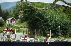 the table is set up with candles and flowers for an outdoor wedding reception in the mountains