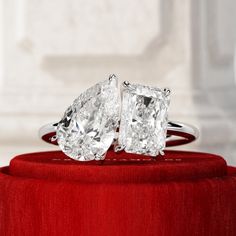 two diamond rings sitting on top of a red box