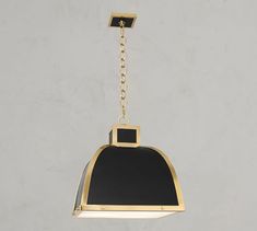 a black and gold bell hanging from a chain on a gray wall with a white background