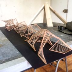 three wooden structures sitting on top of a black table