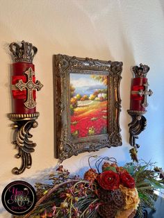 two red candles sitting on top of a table next to a vase with flowers in it