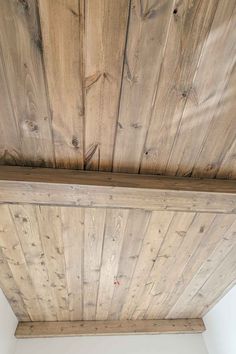 the ceiling is made out of wood planks and has a light fixture on it