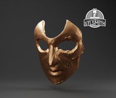 a gold mask with the words, stlsmth on it's side