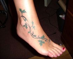 a woman's foot with vines and leaves on the bottom part of her leg