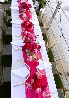 a long table is set with pink and red flowers