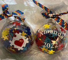 two christmas ornaments with puzzle pieces on them