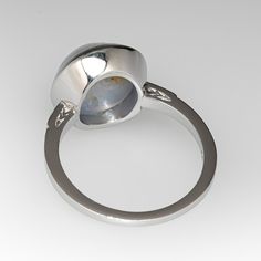 This lovely ring is centered with one (1) round cabochon cut natural star sapphire set into a bezel setting. The shoulders of the ring are each accented with two (2), bead set, round brilliant cut diamonds, bordered with milgrain edging. The ring measures 13.5mm at the top, rises 8.8mm above the finger, tapering to 1.4mm wide and 1.5mm thick at the base of the shank. It is currently a size 7.5. This gorgeous star sapphire has a natural inclusion near the edge but this is very difficult to see wh Luxury Round Cabochons With Bezel Setting, Luxury Cabochons With Bezel Setting, Oval Diamond Cabochons With Polished Finish, Formal Round Gemstone Cabochons, Classic Domed Cabochons With Polished Finish, Luxury Polished Opal Ring, Oval Cabochon, Luxury Opal Ring With Oval Cabochon And Polished Finish, Luxury Polished Opal Ring With Oval Cabochon, Formal Round Cabochons With Bezel Setting