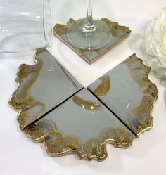 two wine glasses sitting on top of a table next to a plate with a flower