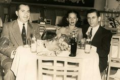 three people sitting at a table with drinks in front of them