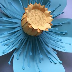 a blue flower with yellow petals on it's center and some water droplets around the petals