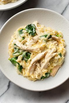 two white bowls filled with pasta and chicken