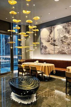 a dining room with tables and chairs covered in yellow tablecloths, chandeliers hanging from the ceiling