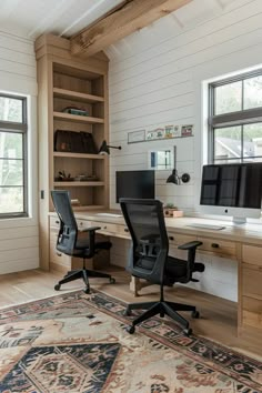 a home office with two computer screens on the desk and an area rug in front of it