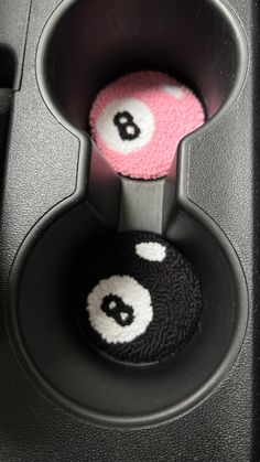 two balls in the center of a black speaker with white and pink numbers on them