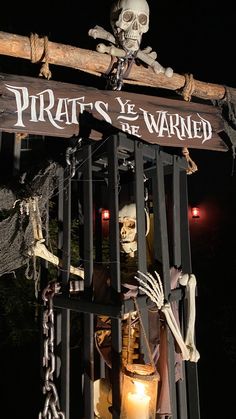 a skeleton in a cage with a sign that says pirates we are wanted on it