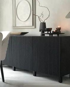 a black and white living room with two candles on the sideboard next to an art piece