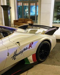 a white sports car parked in front of a building with the word hyperra on it's side